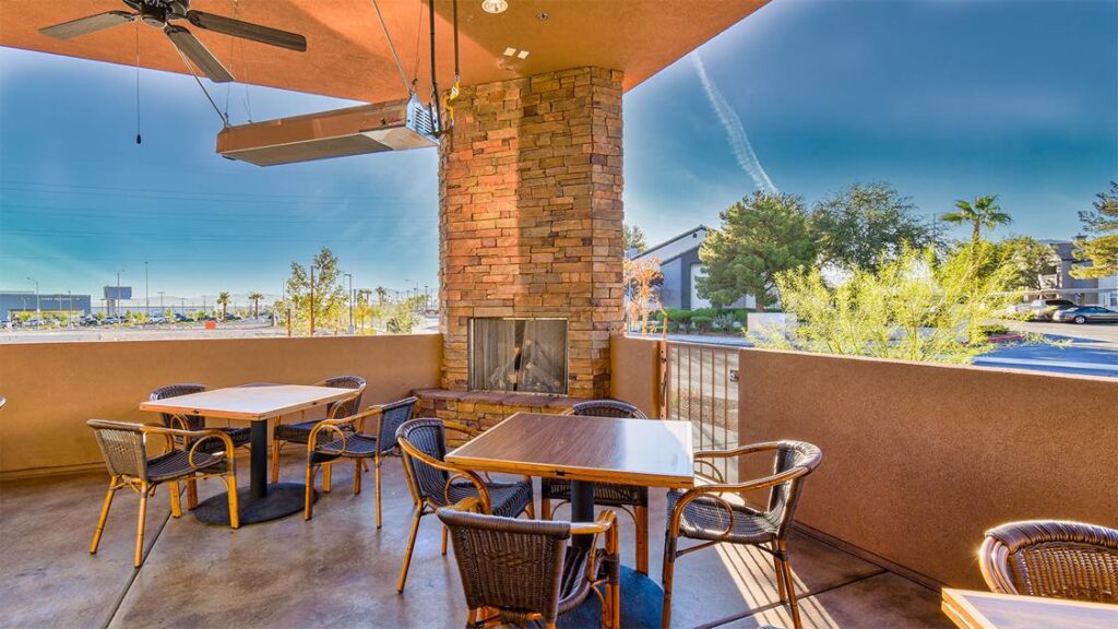 Spacious outdoor dining patio with custom fireplace at Joe's Place bar